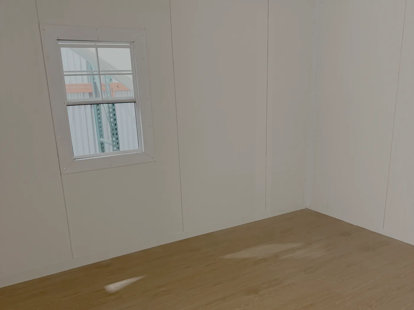The finished interior of an Estia Home, with warm plank flooring, panelled walls and a window